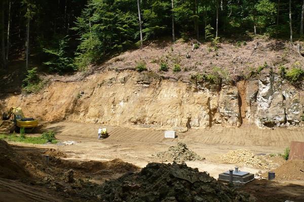 Application et compactage de la couche supérieure de terre sur les bandes de bentonite et l'étanchéité en argile